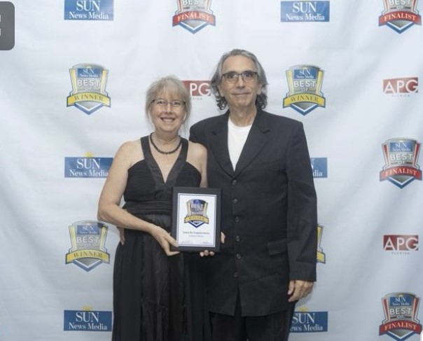 Two people holding an award at an event